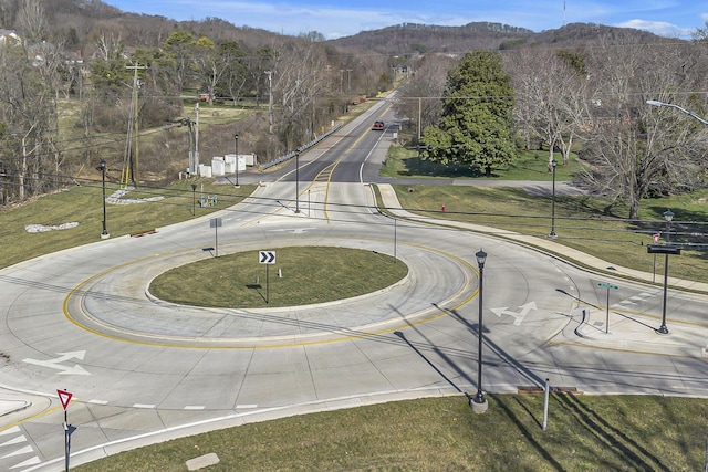 view of road with street lighting, curbs, and a mountain view