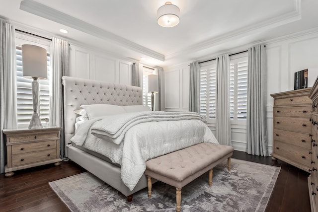 bedroom with crown molding, a tray ceiling, and a decorative wall