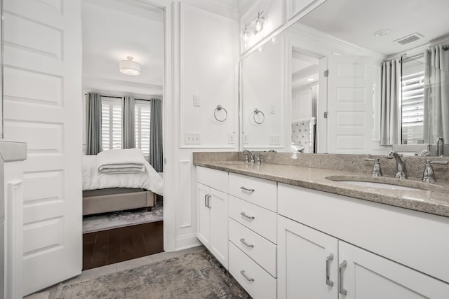 full bath with double vanity, connected bathroom, visible vents, and a sink