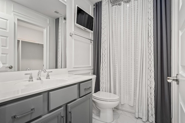 bathroom with visible vents, toilet, a shower with curtain, marble finish floor, and vanity