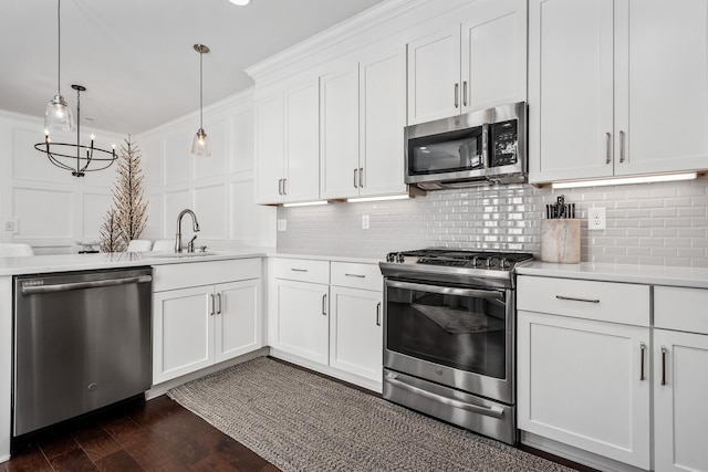 kitchen featuring appliances with stainless steel finishes, crown molding, a decorative wall, and backsplash