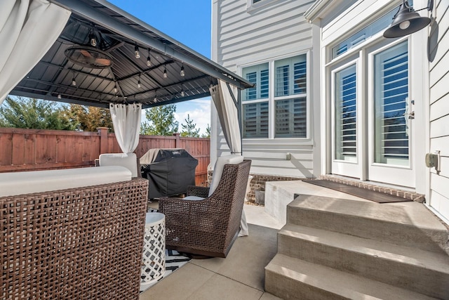 view of patio / terrace with a grill, fence, and a gazebo