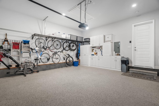 garage with a garage door opener and electric panel