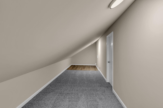 bonus room featuring lofted ceiling, carpet flooring, and baseboards