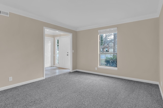 carpeted empty room with baseboards, visible vents, and crown molding