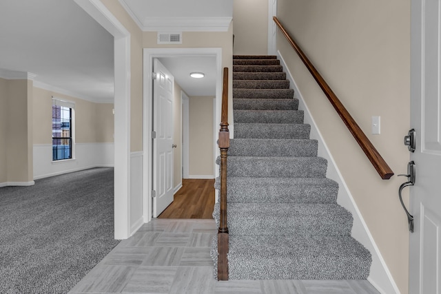 staircase with ornamental molding and visible vents