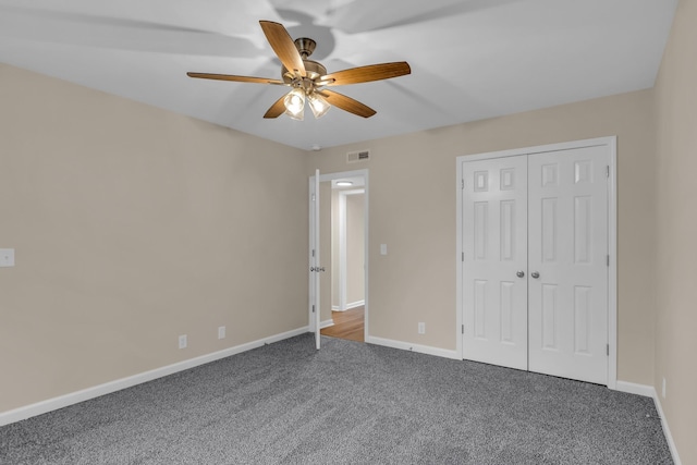 unfurnished bedroom with a closet, carpet, visible vents, and baseboards