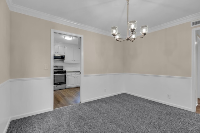 unfurnished dining area featuring a chandelier, dark carpet, and crown molding