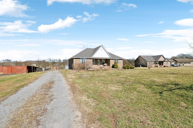 view of front of home featuring an outdoor structure, driveway, and a front lawn