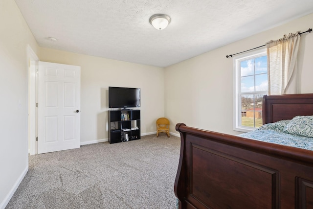 carpeted bedroom featuring a textured ceiling and baseboards