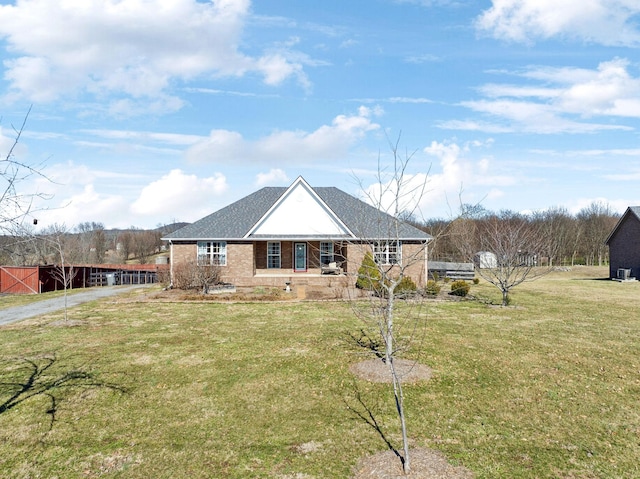 ranch-style home featuring an outbuilding, a front lawn, and brick siding