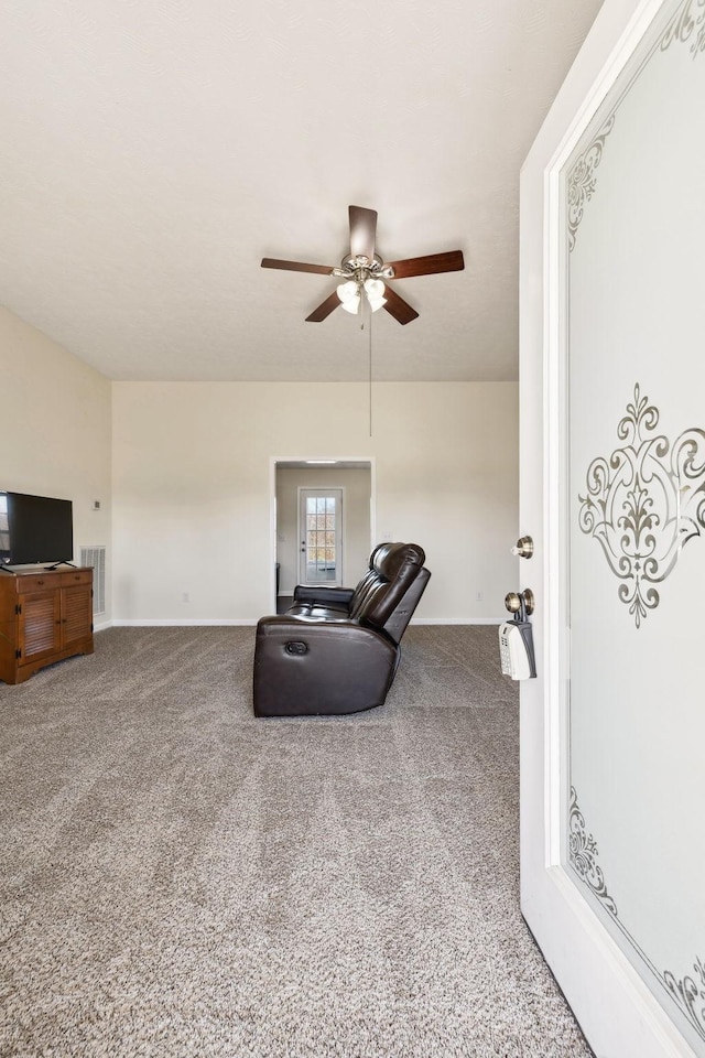 carpeted living room featuring visible vents, ceiling fan, and baseboards