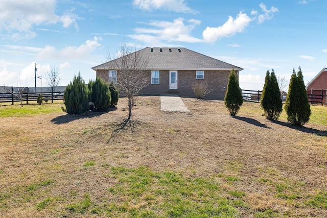 back of property with fence and a lawn