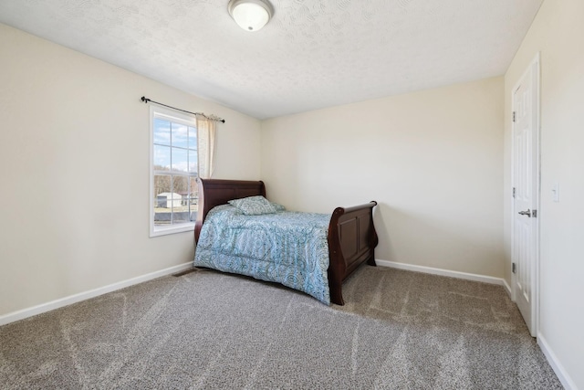 carpeted bedroom with a textured ceiling and baseboards