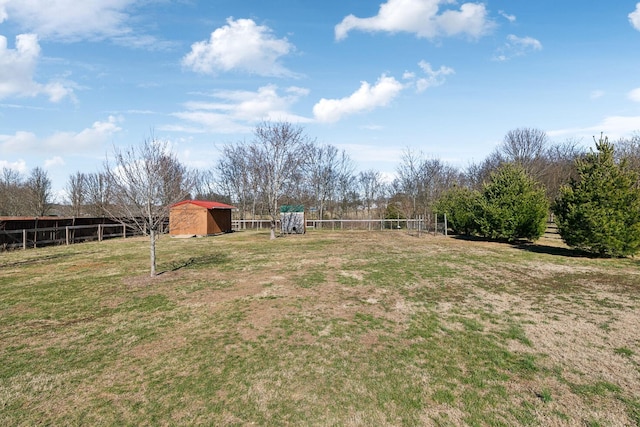 view of yard with a storage shed, fence, and an outbuilding