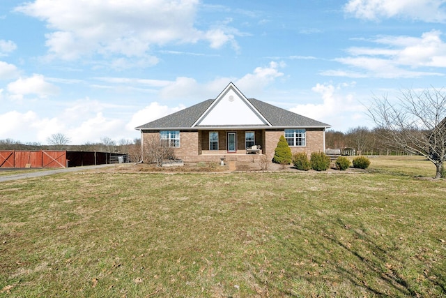 view of front facade with brick siding, an outdoor structure, and a front lawn