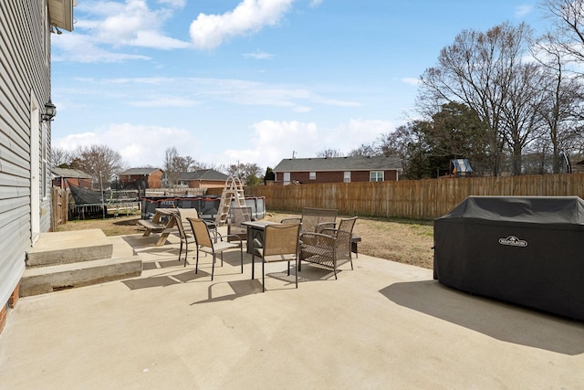 view of patio featuring a fenced backyard, a fire pit, and outdoor dining space