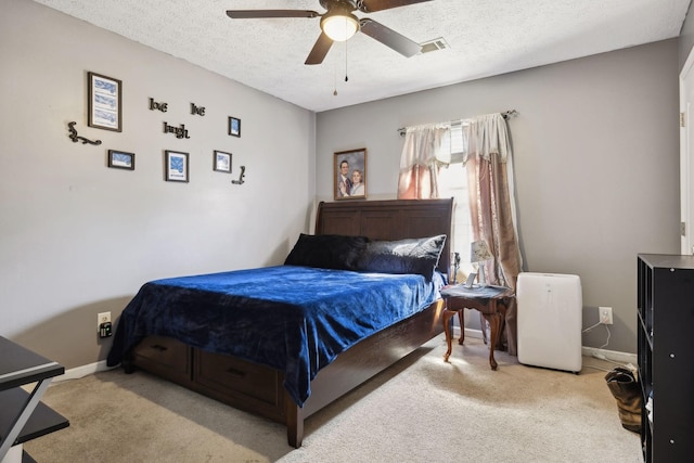 bedroom with a textured ceiling, baseboards, visible vents, and light colored carpet