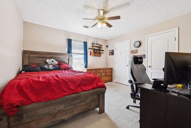 bedroom with a textured ceiling, ceiling fan, carpet, and visible vents