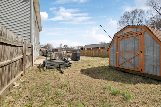 view of yard with an outbuilding, a fenced backyard, and a shed