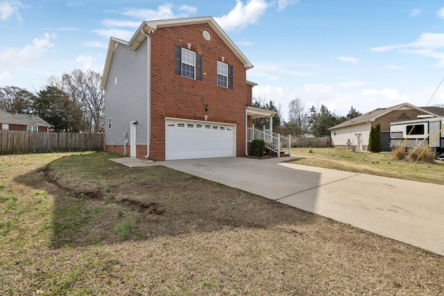 view of home's exterior with brick siding, a lawn, fence, a garage, and driveway