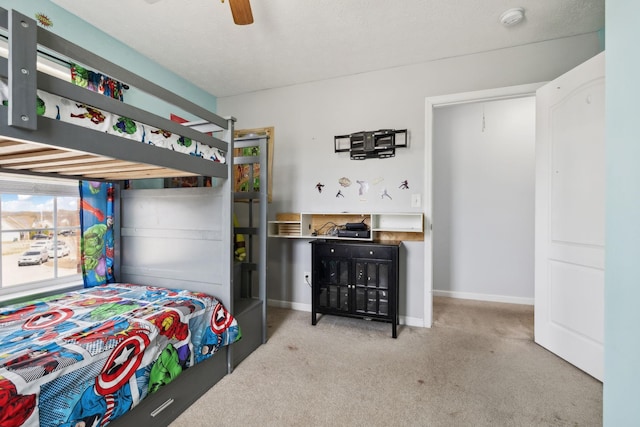 bedroom with ceiling fan, a textured ceiling, carpet flooring, and baseboards