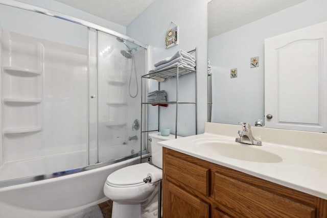 bathroom with bath / shower combo with glass door, a textured ceiling, toilet, and vanity