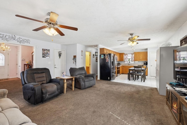 living area featuring light carpet, light tile patterned floors, a textured ceiling, and ceiling fan with notable chandelier