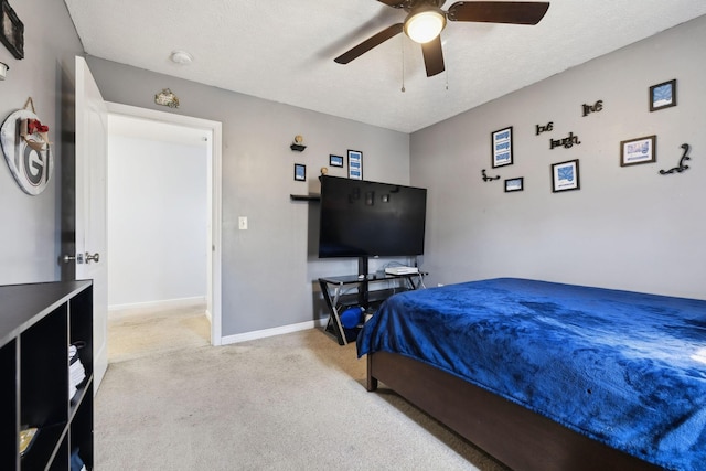 bedroom featuring a ceiling fan, light colored carpet, a textured ceiling, and baseboards