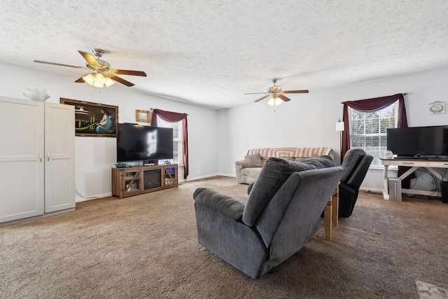 carpeted living area with ceiling fan, a textured ceiling, and baseboards