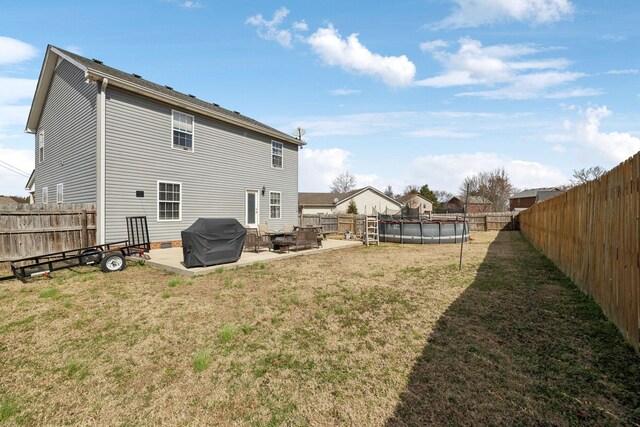 back of house featuring a patio area, a lawn, and a fenced backyard