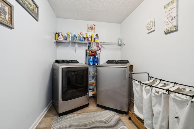 laundry area with a textured ceiling, laundry area, washing machine and clothes dryer, and baseboards