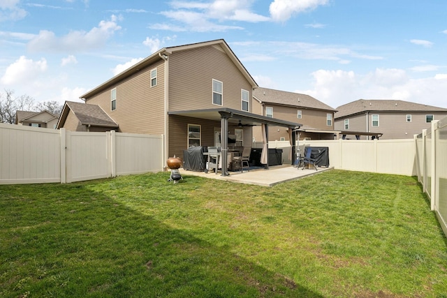 back of property with a fenced backyard, a lawn, and a patio