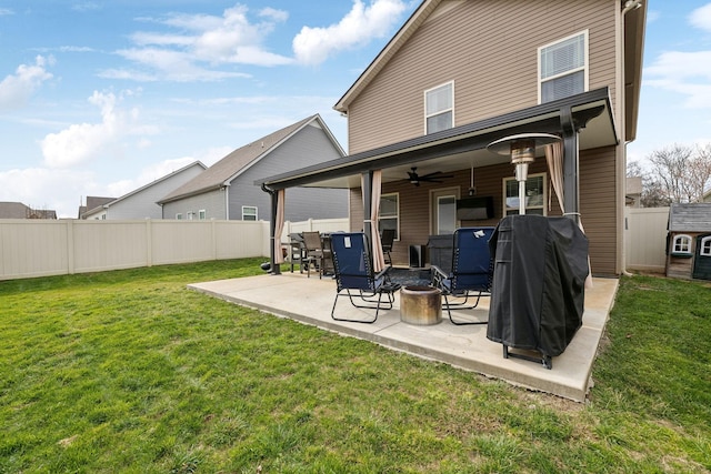 rear view of property featuring a fire pit, a lawn, a patio area, and fence