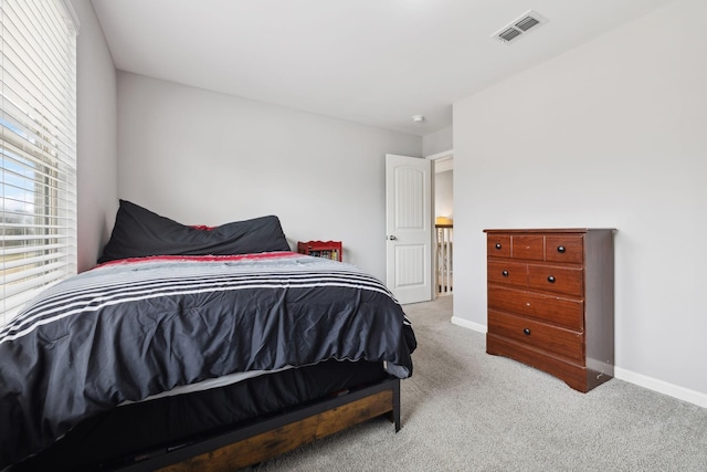 carpeted bedroom with visible vents and baseboards