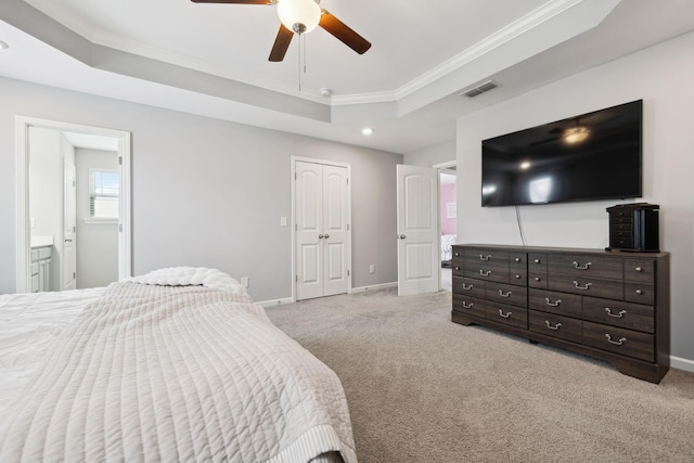 bedroom with light carpet, visible vents, a tray ceiling, and baseboards