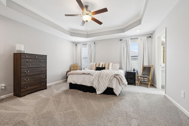 bedroom with ornamental molding, a tray ceiling, carpet, and baseboards