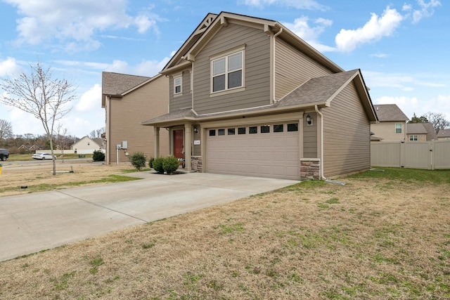 traditional home with concrete driveway, an attached garage, fence, stone siding, and a front lawn