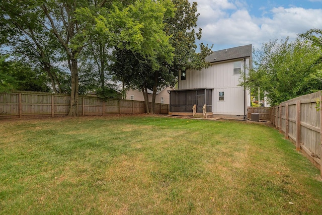 view of yard featuring a sunroom and a fenced backyard