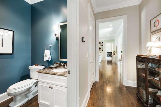 bathroom featuring ornamental molding, toilet, and wood finished floors