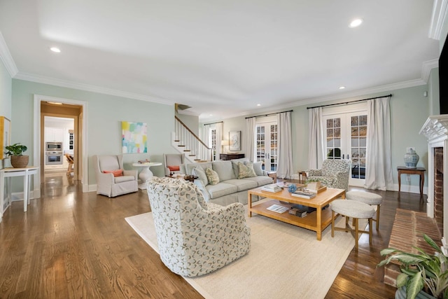 living area featuring stairs, a brick fireplace, dark wood-style floors, and baseboards