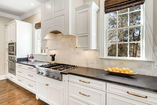 kitchen featuring stainless steel appliances, dark countertops, and crown molding