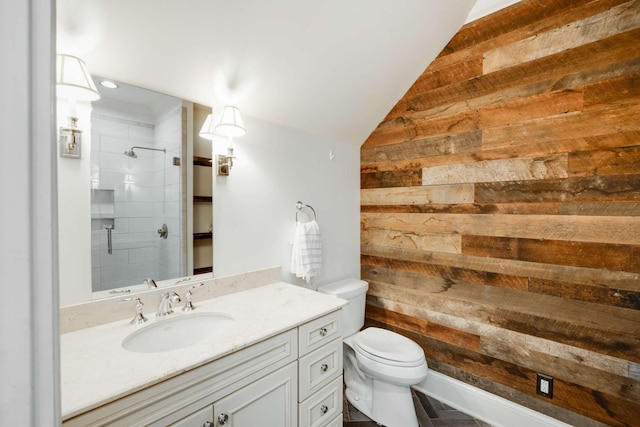 full bathroom featuring vanity, wood walls, a tile shower, and toilet