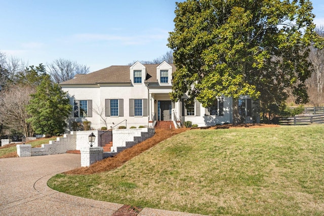 view of front of home with a front yard, fence, and stucco siding