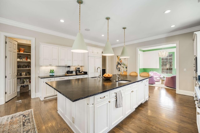 kitchen featuring dark wood-style flooring, a sink, white cabinetry, and crown molding