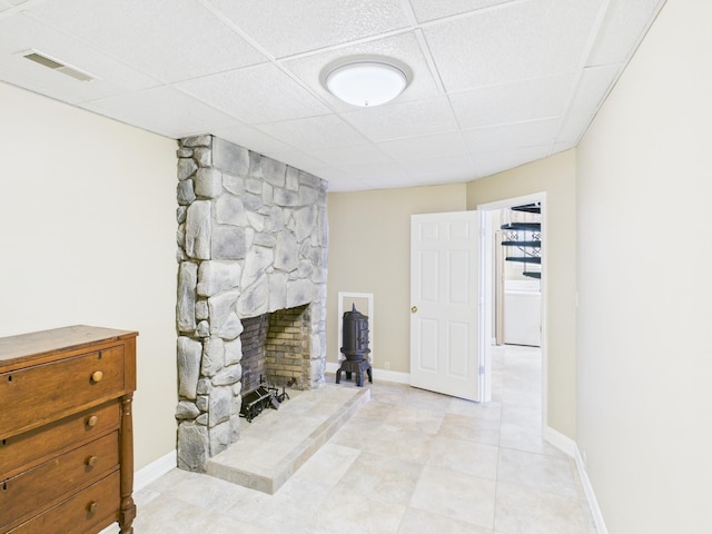 living room with baseboards, a fireplace, visible vents, and a drop ceiling