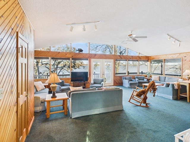 living area with carpet floors, vaulted ceiling, and a textured ceiling