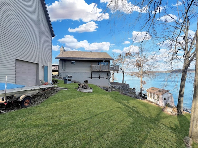 view of yard with a water view and a garage