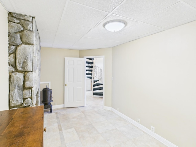 interior space with a paneled ceiling, stairs, and baseboards