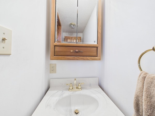 bathroom featuring a textured ceiling and vanity